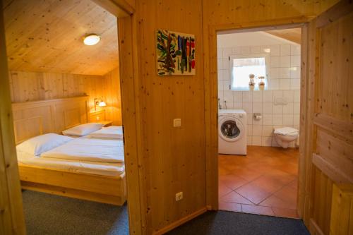 a bedroom with a bed and a washing machine at Alpendorf Dachstein West by ALPS RESORTS in Annaberg im Lammertal