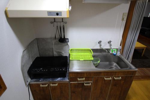 a kitchen with a sink and a green basket at JR福井駅東口から徒歩7分(550m)。一棟貸切民泊トリプレッツ in Fukui