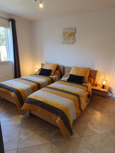 two beds sitting next to each other in a room at CAP CORSE VILLA VUE MER et MONTAGNE in Pietracorbara