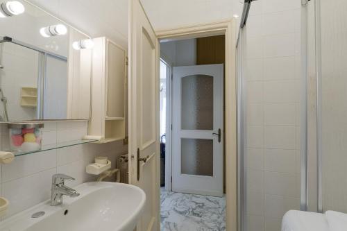 y baño blanco con lavabo y ducha. en Sanremo Portosole Roomy Garden Flat, en San Remo