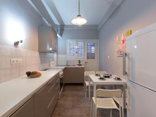 een keuken met een koelkast en een tafel en stoelen bij GORGEOUS center Apartment in Athene