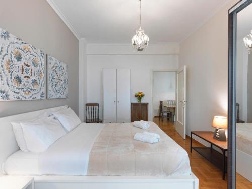 een slaapkamer met een groot wit bed en een tafel bij GORGEOUS center Apartment in Athene