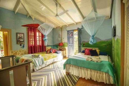 a bedroom with two beds with mosquito netting at Aura Dominica in Roseau