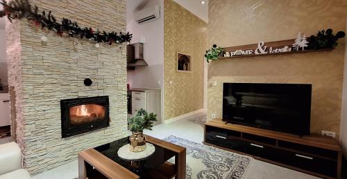 sala de estar con chimenea y TV en Sofia Holiday Haven in Nature with Pool, en Slovenska Bistrica