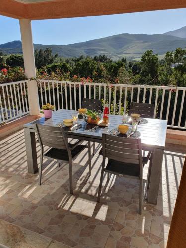 - une table et des chaises sur une terrasse avec vue dans l'établissement CAP CORSE VILLA VUE MER et MONTAGNE, à Pietracorbara