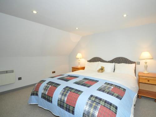 a bedroom with a bed with a cat sitting on it at 2 Bed in Loch Ness GRANY in Invermoriston