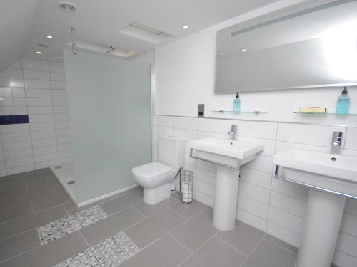 a white bathroom with two sinks and a toilet at 2 Bed in Loch Ness GRANY in Invermoriston