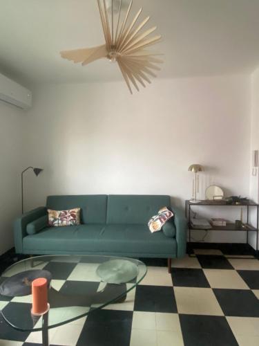 - un salon avec un canapé vert et une table en verre dans l'établissement Charmant appartement 2 chambres à 10mn de la plage., à Marseille