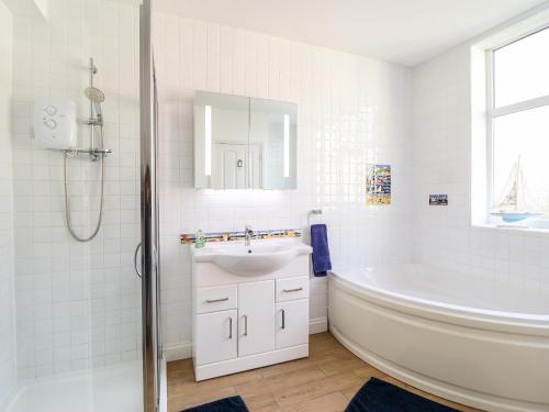 y baño con bañera, lavamanos y bañera. en Meadway House, en Rhôs-on-Sea