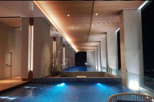 a swimming pool in a building with blue water at Large Comfortable Bedroom in Alam Sutera Tangerang in Kampungklapa 2