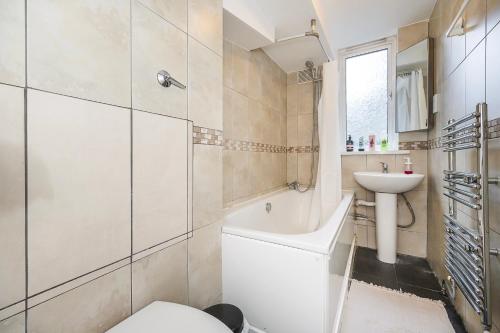 倫敦的住宿－Warm & Cosy Flat in King Cross，一间带卫生间和水槽的浴室