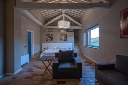a bedroom with a bed and a couch and a chair at Agriturismo La Ratta in Vernasca
