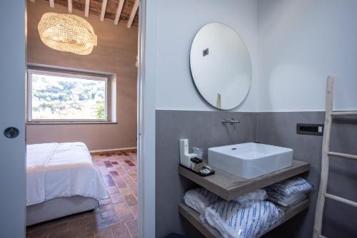 a bathroom with a sink and a bed and a mirror at Agriturismo La Ratta in Vernasca