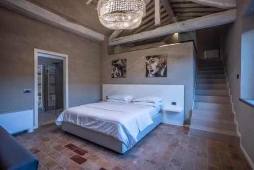 a bedroom with a bed and stairs with a chandelier at Agriturismo La Ratta in Vernasca