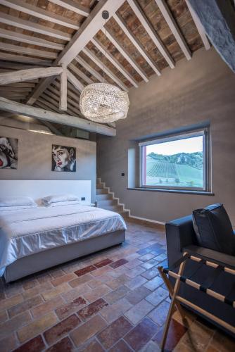 a bedroom with a bed and a chair and a window at Agriturismo La Ratta in Vernasca