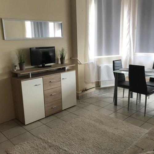 a living room with a table and a television at Visit apartman Tiszafüred in Tiszafüred
