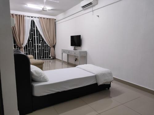 a bedroom with a bed and a tv and a window at ADEEN'S SURIA SUITE, Hotel Mutiara Gua Musang in Gua Musang