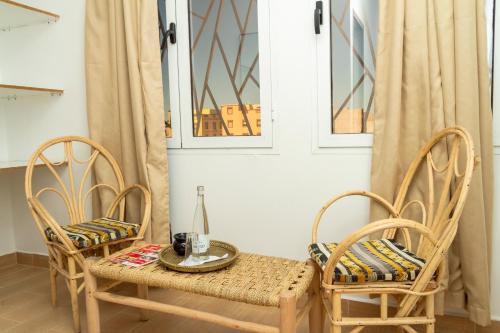 達赫拉的住宿－Hotel WOW，桌子、两把椅子、桌子和椅子以及桌子