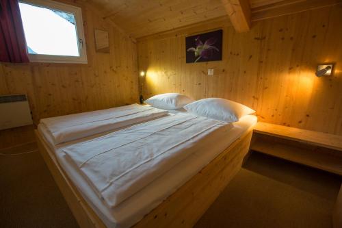 a bedroom with a large bed in a wooden room at Alpendorf Dachstein West by ALPS RESORTS in Annaberg im Lammertal