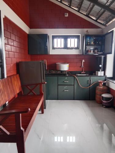una cocina con armarios verdes y un banco. en Mistymout Homestay, en Attappādi