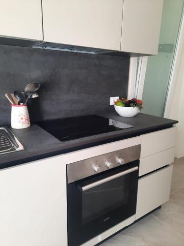 a kitchen with a stove and a bowl of fruit at Azzurro Mare Aparthotel in Torre Mozza