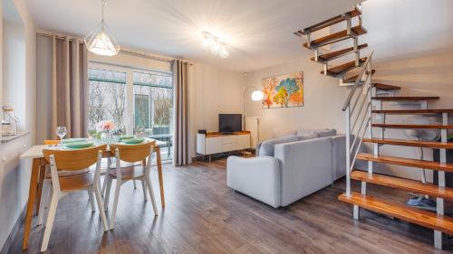 a living room with a dining room table and a staircase at Jasne Wybrzeże, Sun & Snow in Jastrzębia Góra