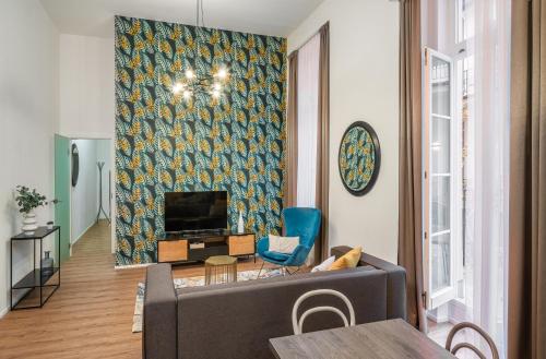 - un salon avec un canapé et une télévision dans l'établissement VN48 Suites by Adrez, à Prague