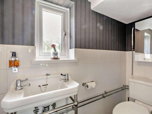 uma casa de banho com um lavatório, um WC e uma janela. em 3 Bed in Brighton 64950 em Saltdean