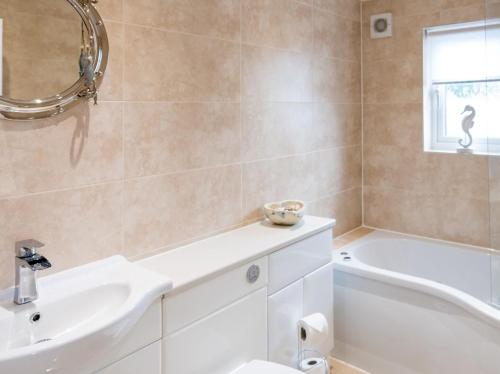 een badkamer met een wastafel, een bad en een toilet bij 3 Bed in Westward Ho 64410 in Northam