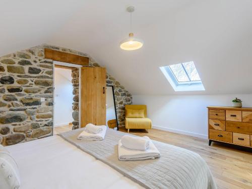 a bedroom with a bed and a stone wall at 3 Bed in Aberdovey 75025 in Llwyngwril