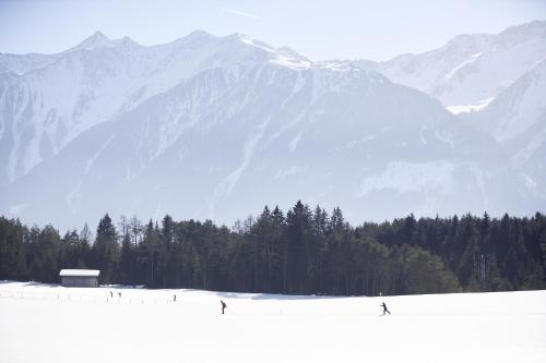 a group of people skiing in front of a snow covered mountain at Ferienwohnungen Kail Thomas in Obsteig