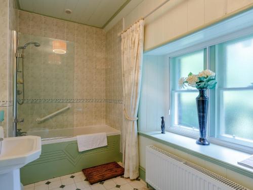 La salle de bains est pourvue d'une baignoire, d'un lavabo et d'une fenêtre. dans l'établissement 5 Bed in Loch Ness 78538, à Drumnadrochit