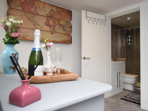 a room with a bottle of wine and flowers on a counter at 1 Bed in Durham 76615 in Lanchester