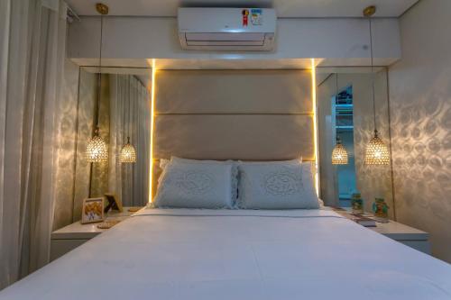 1 dormitorio con 1 cama blanca grande con luces en Vacation Fortaleza Apartment, en Fortaleza
