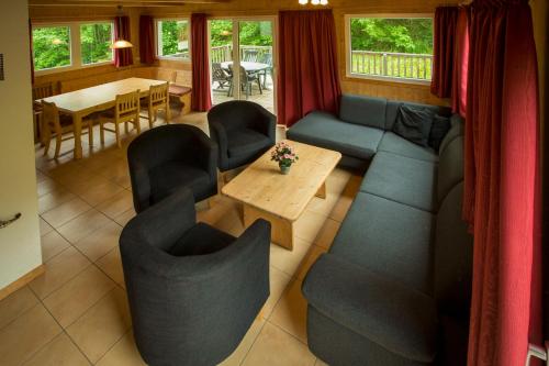 a living room with a couch and chairs and a table at Alpendorf Dachstein West by ALPS RESORTS in Annaberg im Lammertal