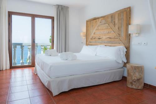 a bedroom with a large white bed and a window at Hostal La Torre Ibiza Cap Negret in San Antonio