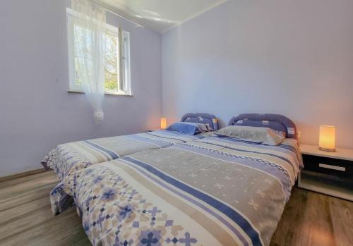 a bedroom with two beds and a window at Crveni Vrh A4+2 in Crveni Vrh