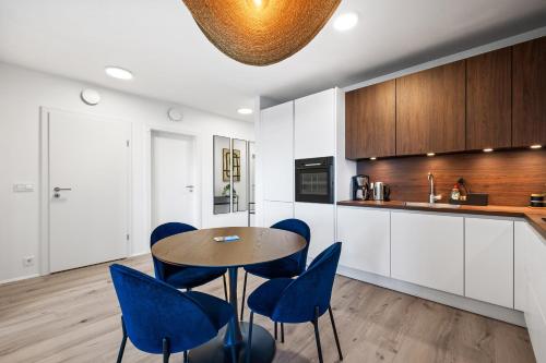 a kitchen with a table and blue chairs at New Apt Near Smáralind Mall With Private Parking in Reykjavík