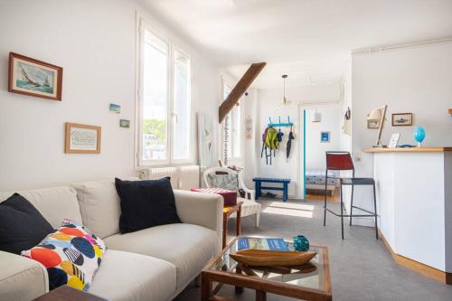un salon avec un canapé blanc et une table dans l'établissement Appart' confort Les Maôves Parking privé, à Étretat