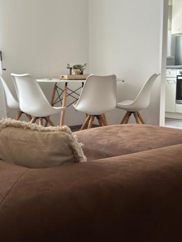 a group of white chairs and a table in a room at Appartement Elena in Linz