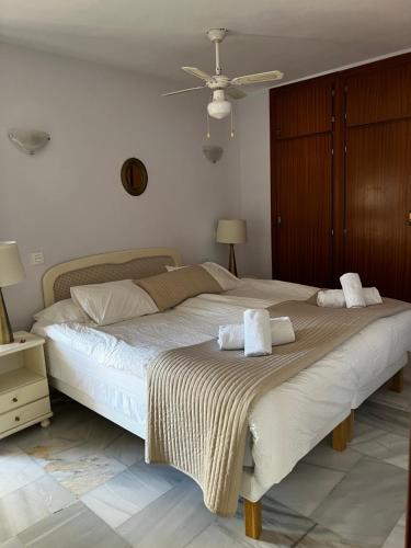 um quarto com uma cama grande e toalhas em Arena Beach em Estepona