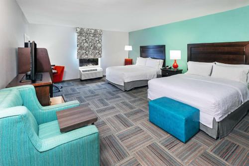 una camera d'albergo con due letti e un divano di Hampton Inn Miami, Oklahoma a Miami