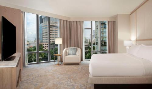 a hotel room with a bed and a large window at Hilton West Palm Beach in West Palm Beach