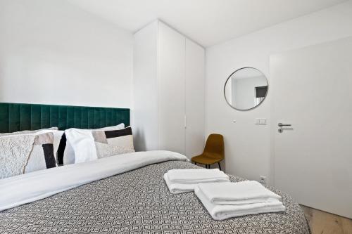 a bedroom with a bed with a green headboard and a mirror at New Apt Near Smáralind Mall With Private Parking in Reykjavík