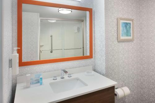 a bathroom with a white sink and a mirror at Hampton Inn & Suites Myrtle Beach Oceanfront in Myrtle Beach