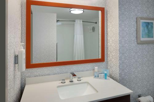 a bathroom with a white sink and a mirror at Hampton Inn & Suites Myrtle Beach Oceanfront in Myrtle Beach