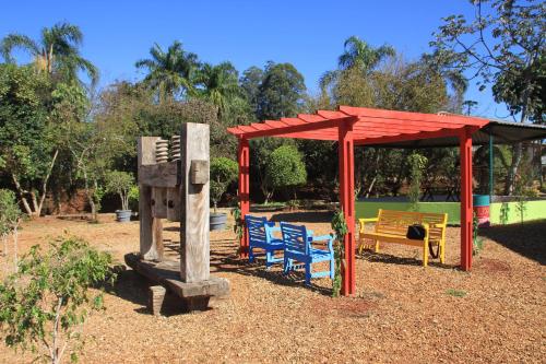 a playground with chairs and a pavilion and a bench at Villa Verde Hotel in Avaré