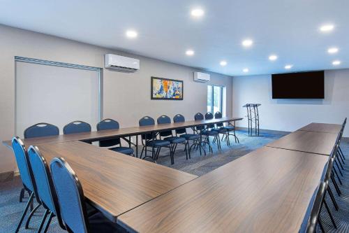 a conference room with tables and chairs and a screen at La Quinta by Wyndham Nashville Airport in Nashville