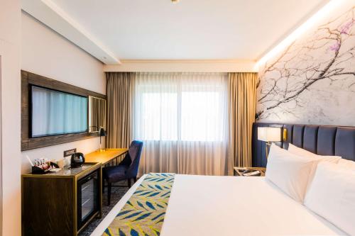 a hotel room with a bed and a desk at Garden Court Hatfield in Pretoria