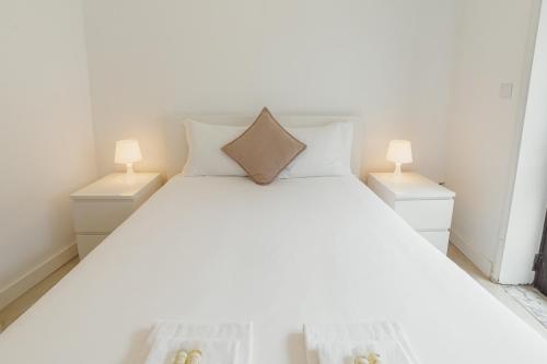 een slaapkamer met een wit bed en 2 nachtkastjes bij Pateo In Lapa City Center by Vacationy in Porto